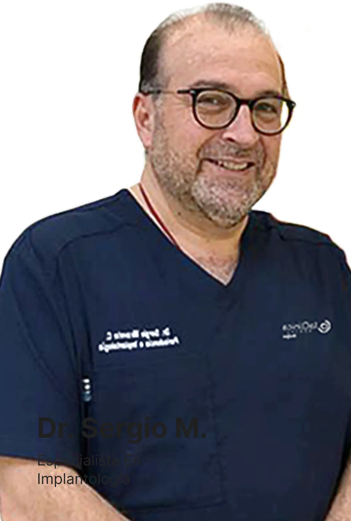 Dr. Sergio M., especialista en implantología, sonriendo con bata de clínica dental.