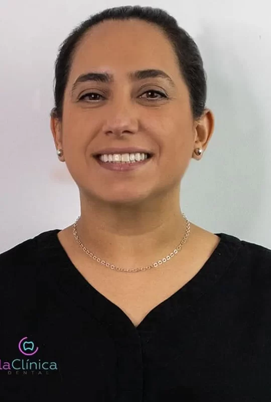 Dra. Rosa Ma. M. sonriente en uniforme dental, representando al equipo profesional de La Clínica Dental.