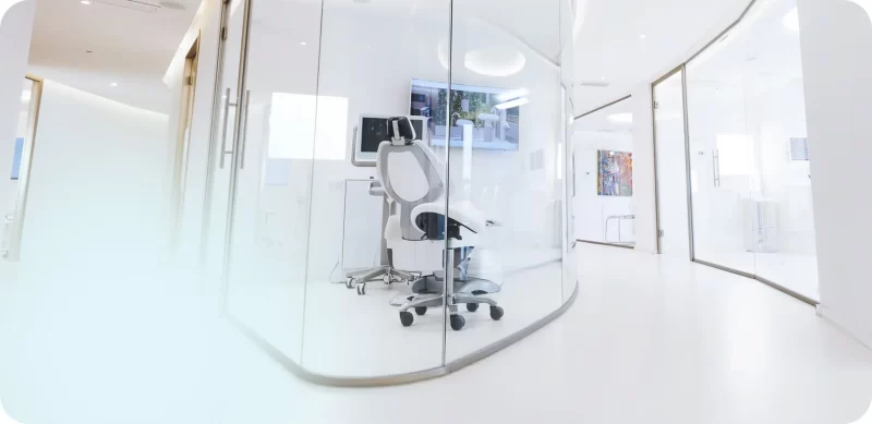 Consultorio dental moderno con silla de paciente y pantalla, enfatizando la importancia de un ambiente cómodo y profesional para superar los miedos asociados a las visitas dentales.