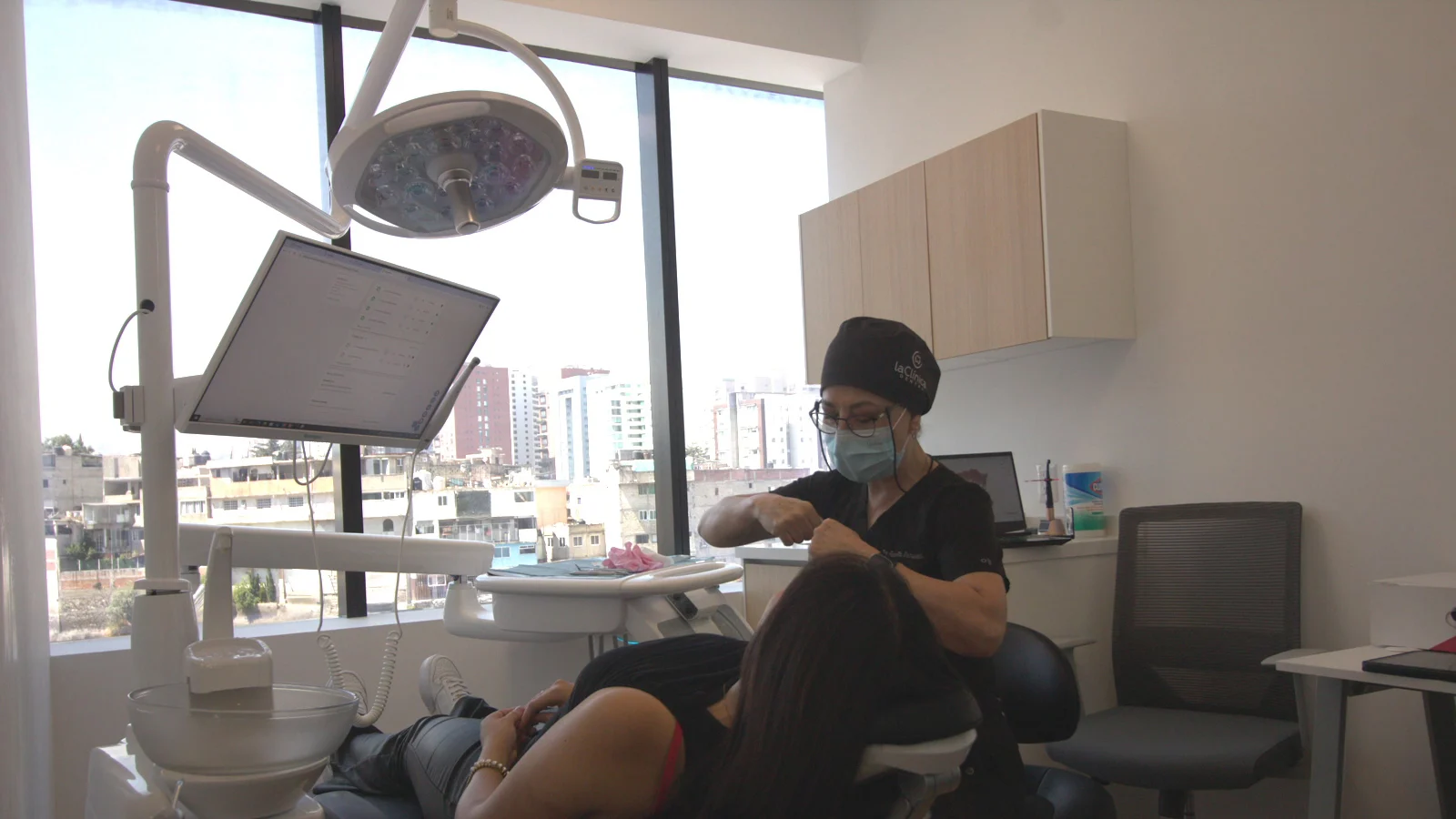 Dentista realizando un procedimiento dental en paciente, con tecnología moderna y ambiente clínico en La Clínica Dental, destacando la importancia de la precisión en tratamientos como implantes guiados por computadora.