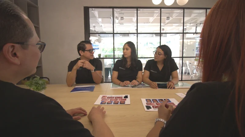 Equipo de especialistas en La Clínica Dental discutiendo opciones de tratamientos dentales y mostrando imágenes de casos en una reunión.